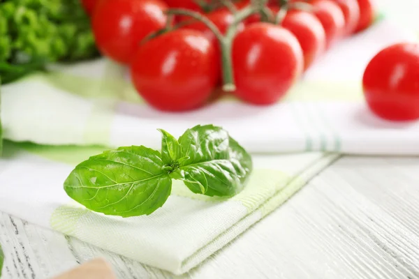 Pomodori ciliegia con basilico sul tavolo da vicino — Foto Stock