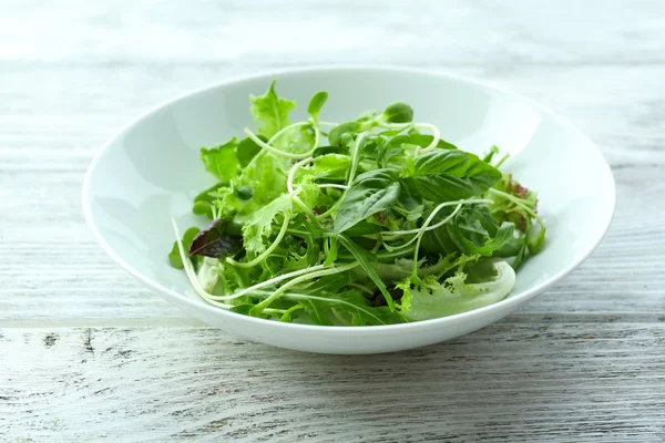 Salada verde mista fresca em tigela na mesa de madeira close-up — Fotografia de Stock