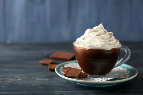 Cup of coffee with cream on color wooden background — Stock Photo, Image