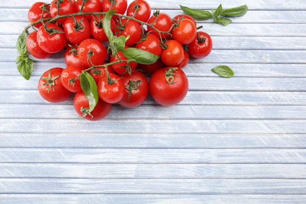 Pomodori ciliegini freschi con basilico sul tavolo di legno da vicino — Foto Stock