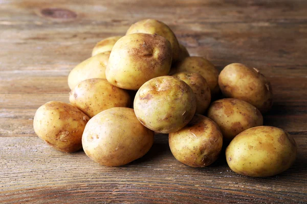 Batatas jovens na mesa de madeira perto — Fotografia de Stock