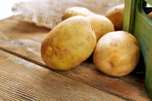 Jonge aardappelen op houten tafel close-up — Stockfoto