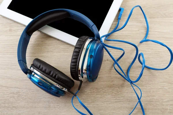 Headphones with tablet on  table — Stock Photo, Image