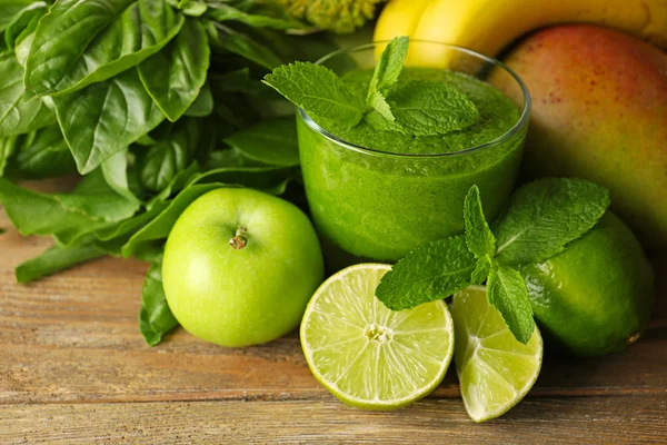Succo sano verde con frutta ed erbe sul tavolo da vicino — Foto Stock