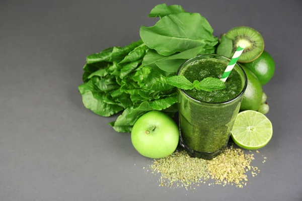 Jus vert sain avec des fruits et des herbes sur fond gris — Photo