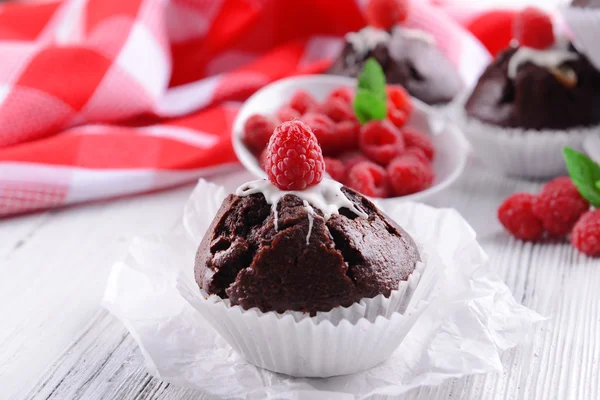 Delicious chocolate cupcakes with berries and fresh mint on table close up — Stock Photo, Image