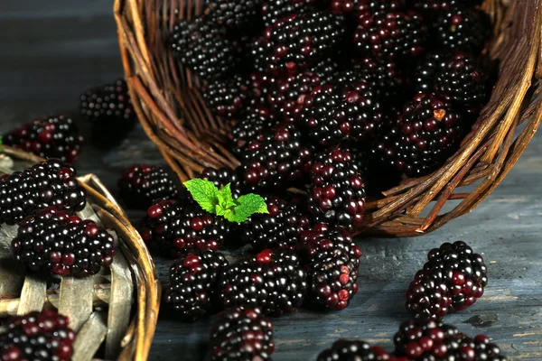 Un mucchio di more dolci con menta nel cesto sul tavolo da vicino — Foto Stock