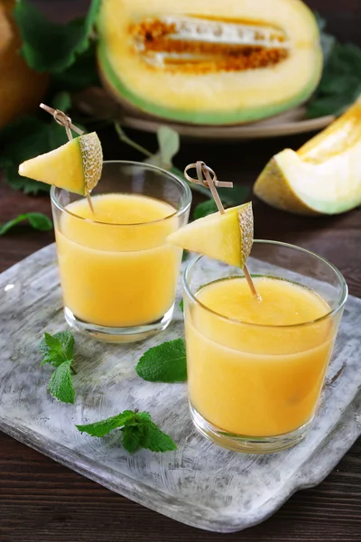 Glasses of melon cocktail on wooden background — Stock Photo, Image