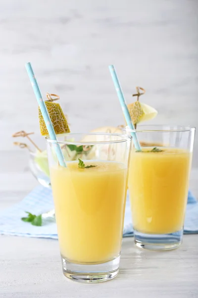 Glasses of melon cocktail on white wooden background — Stock Photo, Image