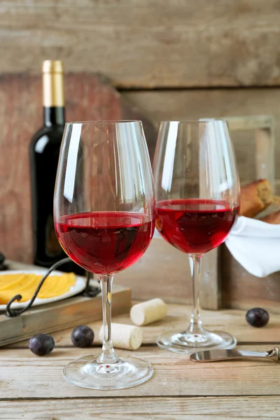 Stillleben von Wein, Trauben, Käse und Brot auf rustikalem Holzgrund — Stockfoto