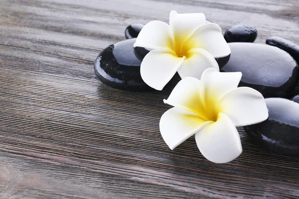 Piedras de spa húmedas con flores —  Fotos de Stock