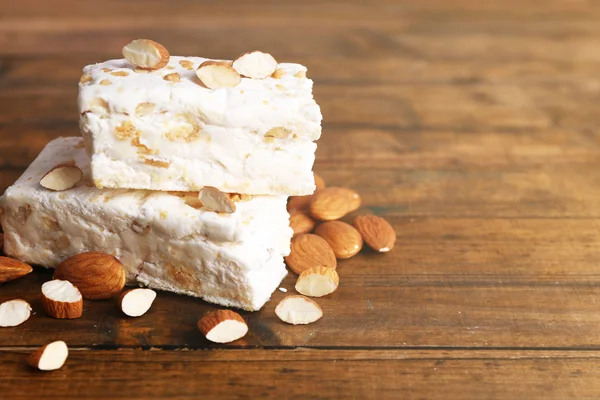 Sweet nougat with almonds on wooden background — Stock Photo, Image