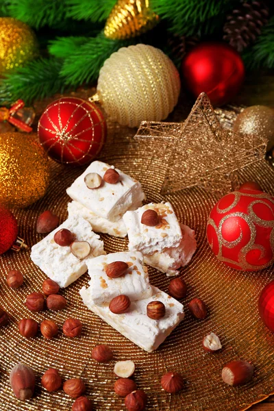 Turrón dulce con avellanas y mesa de decoración de Navidad de cerca —  Fotos de Stock