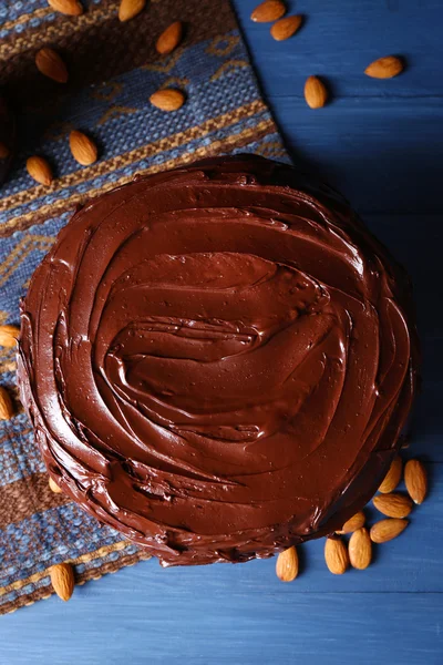 Аппетитный шоколадный торт среди миндаля на голубом фоне — стоковое фото