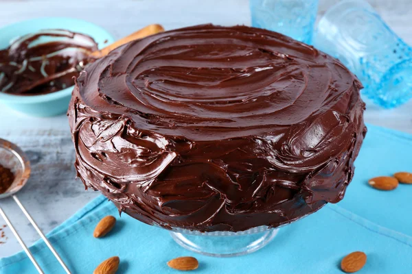 Смачний торт під шоколадною глазур'ю на світло-блакитному фоні — стокове фото
