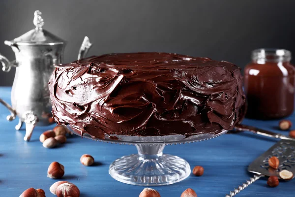 Lahodný dort s glazuře čokolády na modré dřevěný stůl — Stock fotografie
