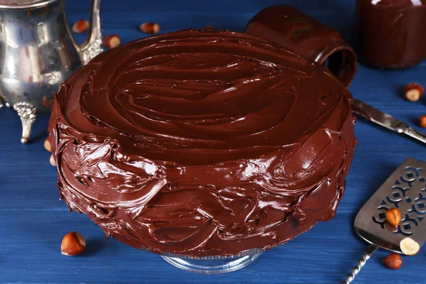 Delicioso pastel con glaseado de chocolate líquido en la mesa de madera azul —  Fotos de Stock
