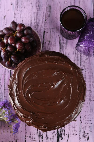Välsmakande choklad paj med söt druvmust och glas te på trä bakgrund — Stockfoto