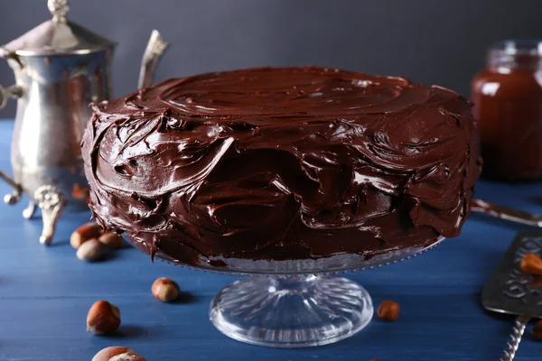 Delicioso pastel con glaseado de chocolate líquido en la mesa de madera azul — Foto de Stock