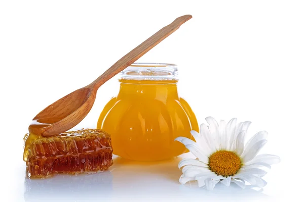 Pot of honey, wooden spoon and honeycomb isolated on white — Stock Photo, Image