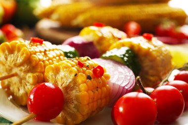 Sebze ve yeşil ekose deseni peçete eşliğinde lezzetli ızgara mısır