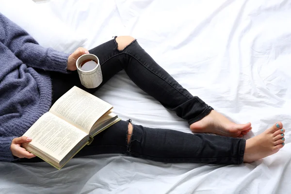 Vrouw op het bed met oud boek en kopje koffie, bovenaan oogpunt — Stockfoto