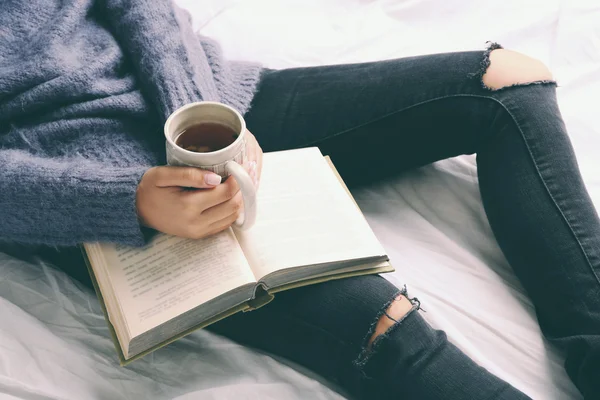 Donna sul letto con vecchio libro e tazza di caffè, punto di vista dall'alto — Foto Stock