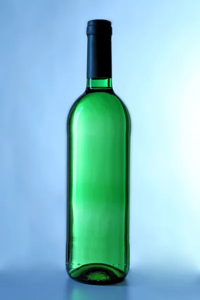 Láhev vína na modrém pozadí — Stock fotografie