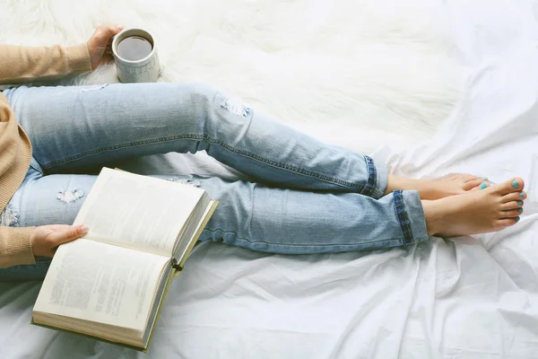 Vrouw op het bed met oud boek en kopje koffie, bovenaan oogpunt — Stockfoto