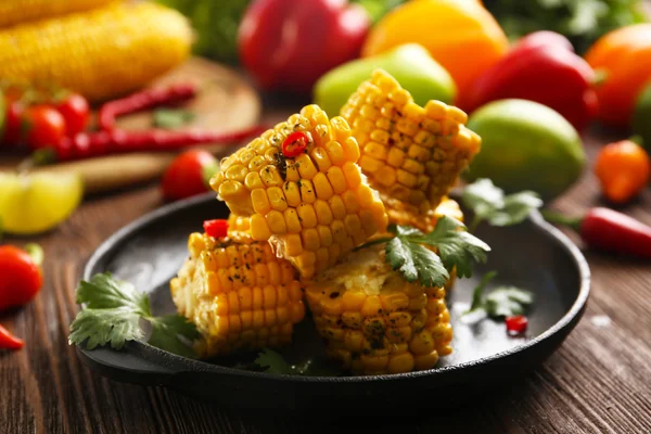 Tasty grilled corn and vegetables on black crockery — Stock Photo, Image