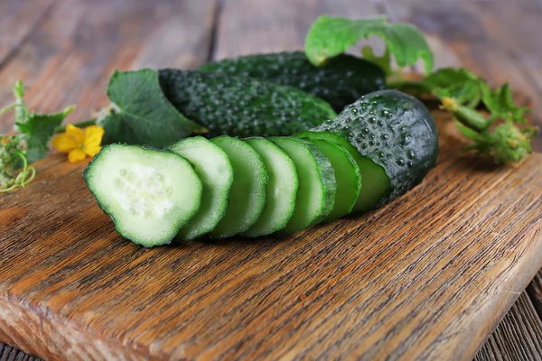 Sliced cucumbers on wooden table — Stock Photo, Image