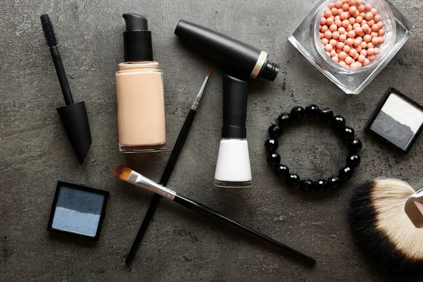 Cosmetici diversi su sfondo grigio scuro — Foto Stock