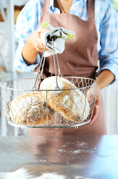 Пекарь проверяет свежеиспеченный хлеб — стоковое фото