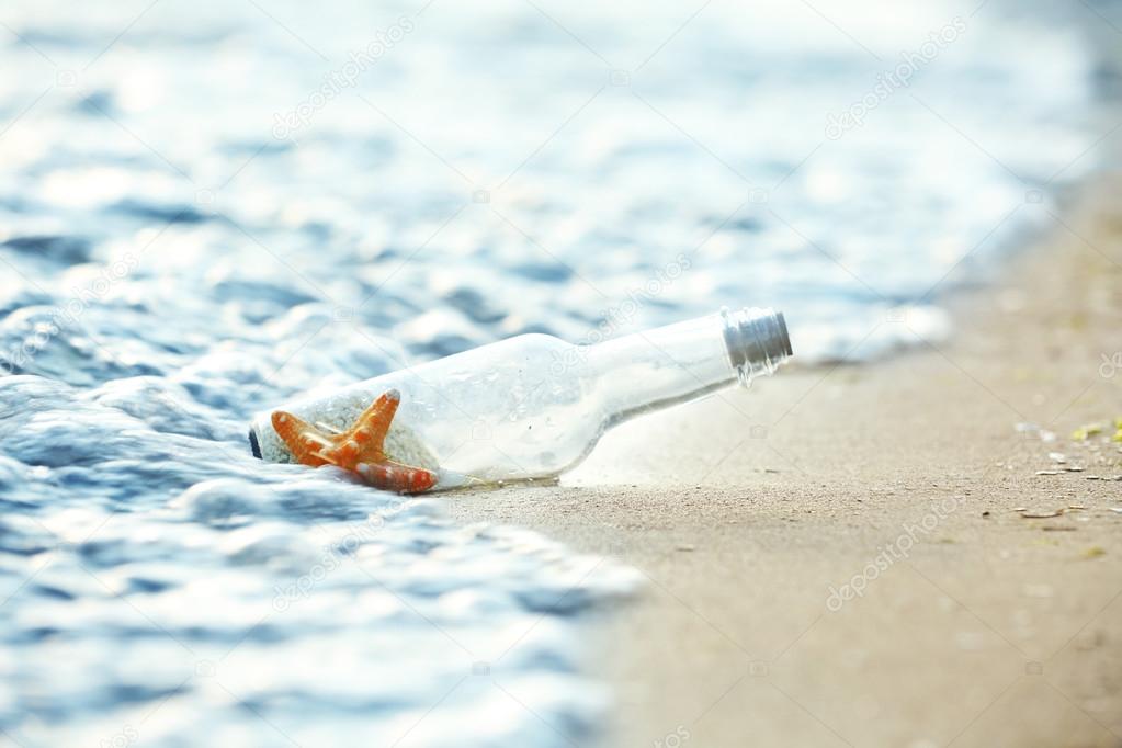 Bottle with starfish on beach