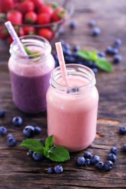 Çilek, yaban mersini ve ahşap zemin üzerine nane ile dekore edilmiş Berry yoğurt