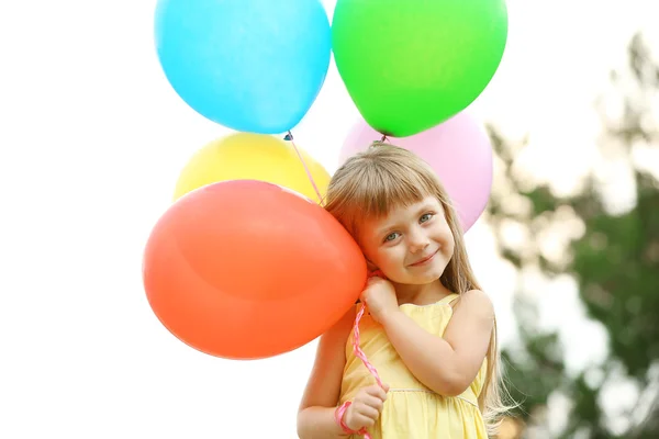 Kleines Mädchen mit Luftballons — Stockfoto