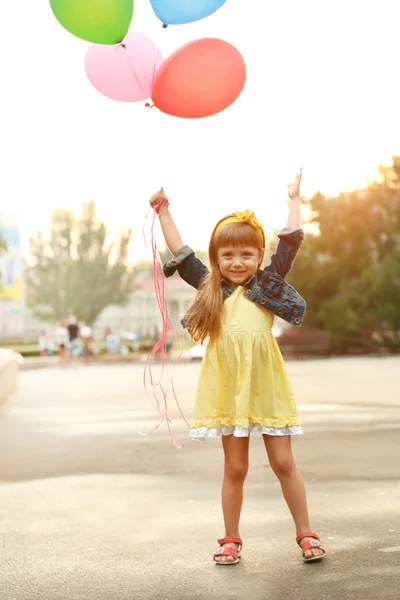 Liten flicka med ballonger — Stockfoto