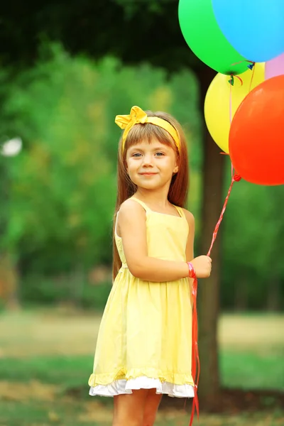 Liten flicka med ballonger — Stockfoto