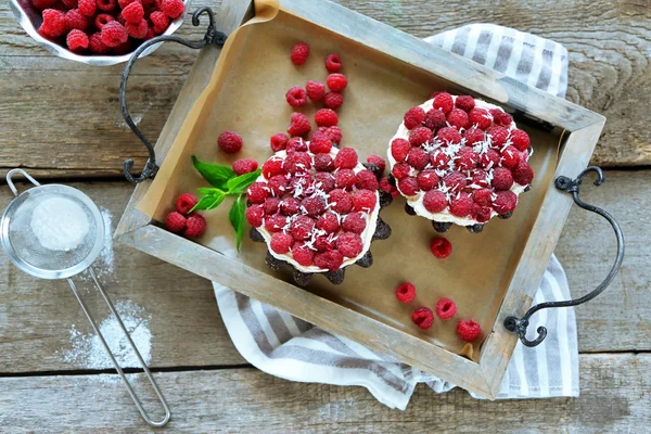 Sweet cakes with raspberries on wooden table background — Stock Photo, Image
