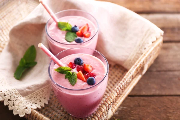 Fresh strawberry yogurt on wicker tray on wooden background — Stock Photo, Image