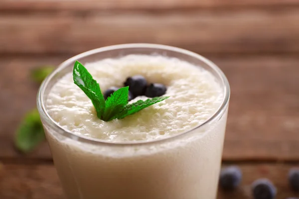 Färsk yoghurt med mynta och blåbär på trä bakgrund — Stockfoto