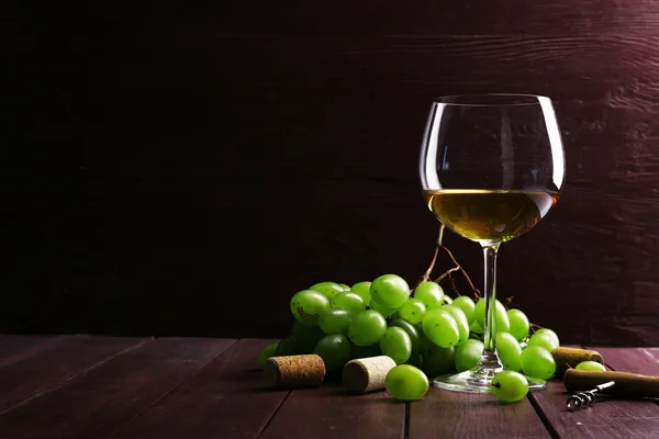 Glass of wine with grape on wooden background — Stock Photo, Image