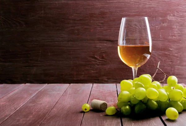 Verre de vin avec raisin sur fond en bois — Photo