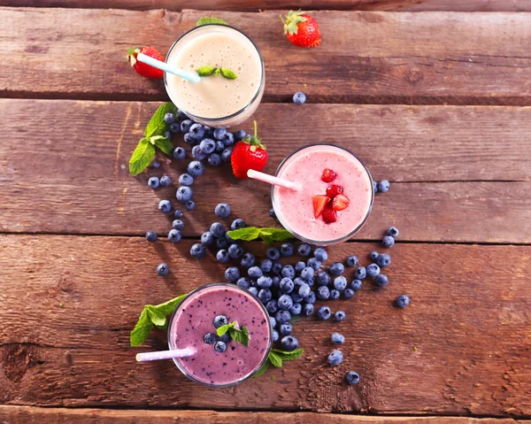 Tasty blueberry, strawberry and milk yogurts — Stock Photo, Image