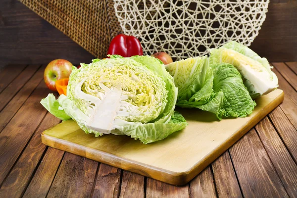 Cut savoy cabbage and pepper on wooden cutting board closeup — Stock Photo, Image