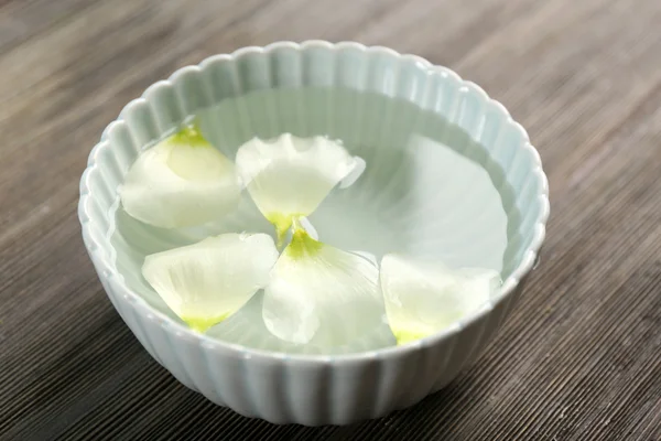 Petali di fiori in ciotola con acqua — Foto Stock