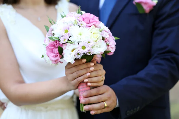 Brud och brudgum håller bröllop bukett — Stockfoto