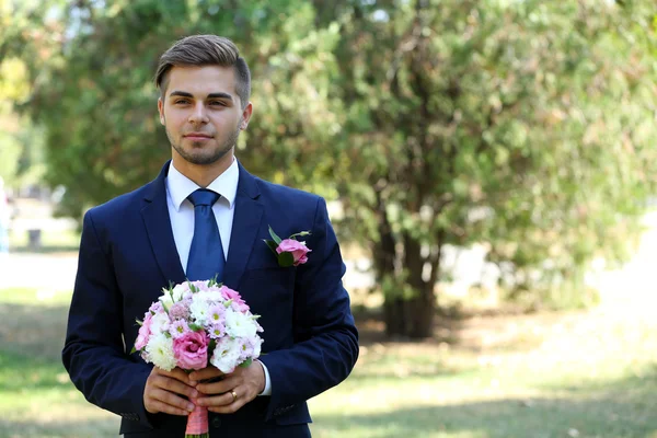 Noivo segurando buquê de casamento — Fotografia de Stock