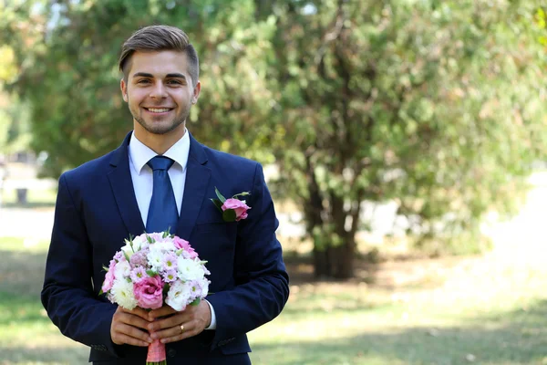 Noivo segurando buquê de casamento — Fotografia de Stock