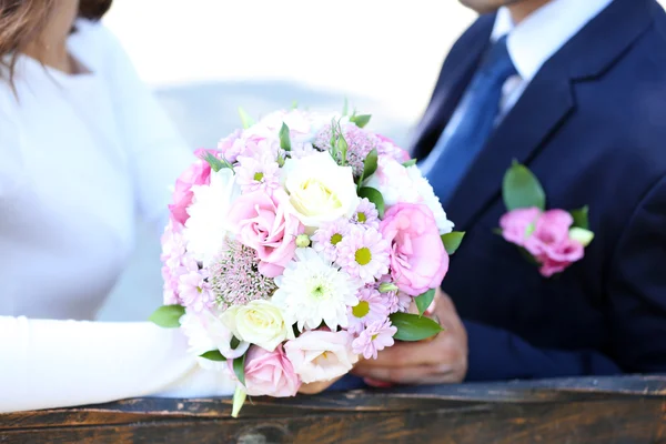 Sposa e sposo tenendo bouquet da sposa — Foto Stock